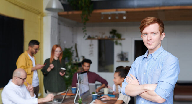 man-standing-beside-people-sitting-beside-table-with-laptops-3184395.jpg